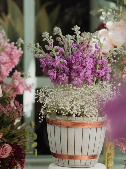 A close-up of a floral arrangement in a rustic, striped pot. The soft focus and beautiful colors create a dreamy and romantic image.