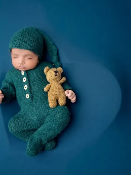 A spotlight effect highlights this peacefully sleeping newborn, creating a dramatic and artistic portrait.