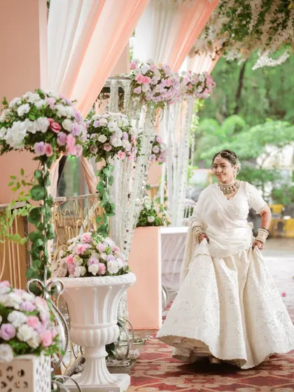A happy, candid shot of the bride walking through the beautifully decorated wedding aisle. Her smile lights up the frame.