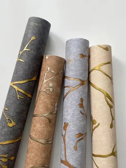 A collection of four wallpaper rolls with a branch pattern in different color combinations, including grey, brown, and beige.