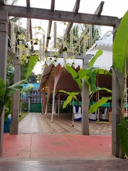 Another view of the traditional entrance, showing the hanging floral strings from a wooden pergola.