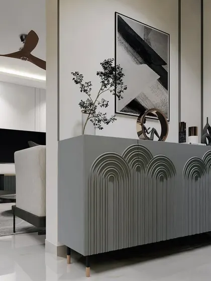 A custom-designed console table with carved arch details serves as a beautiful and functional piece in the foyer.