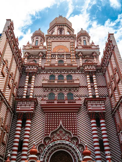 The stunning architecture of the Jami Ul-Alfar Mosque, also known as the Red Mosque, in Colombo. The intricate red and white patterns are a photographer's dream.
