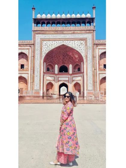 A panoramic-style shot of me at the entrance of the Taj Mahal, capturing the grand scale of the architecture.