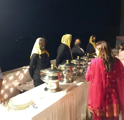 Our staff serving guests at a rooftop dinner buffet. We provide attentive service throughout the event, ensuring the buffet is always stocked and guests have everything they need.