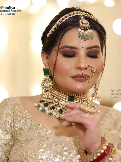 A soft and elegant bridal look with a gold lehenga, featuring a simple but chic hairstyle with a matha patti.