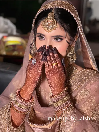 A classic shy bride pose. Her dusty pink outfit is so elegant, and the makeup is soft and romantic.