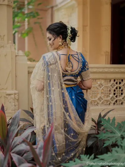 A beautiful shot of the bride from the back, showcasing her hairstyle and the intricate design of her blouse.