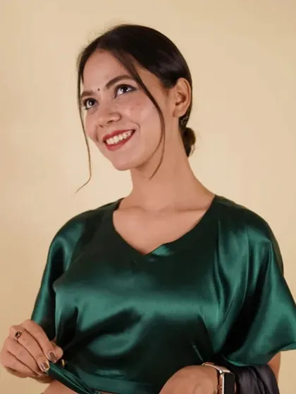 An elegant emerald green satin blouse with bell sleeves and a tie-waist. The rich color and modern cut make it a standout piece.