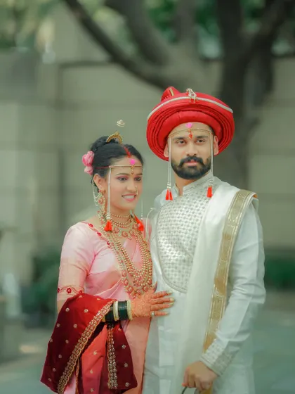 A full-length portrait showcasing the couple's stunning traditional Maharashtrian wedding attire.