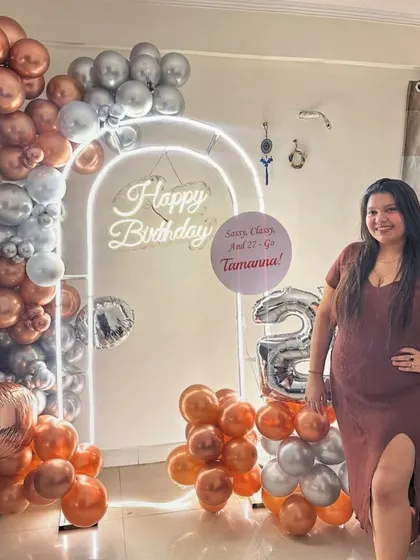 A happy client posing with her personalized 27th birthday decorations. Our goal is to make you feel celebrated.