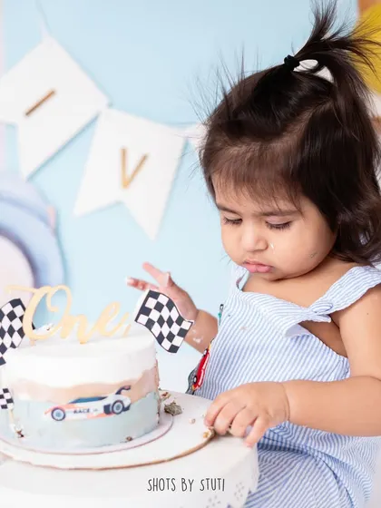 A future mechanic in the making? Here, he's carefully inspecting the racing flags on his cake before the main event. These little interactions are what make each cake smash session unique.