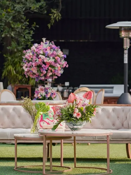 A more relaxed seating area on the lawn, with comfortable sofas and floral arrangements, perfect for a daytime event.
