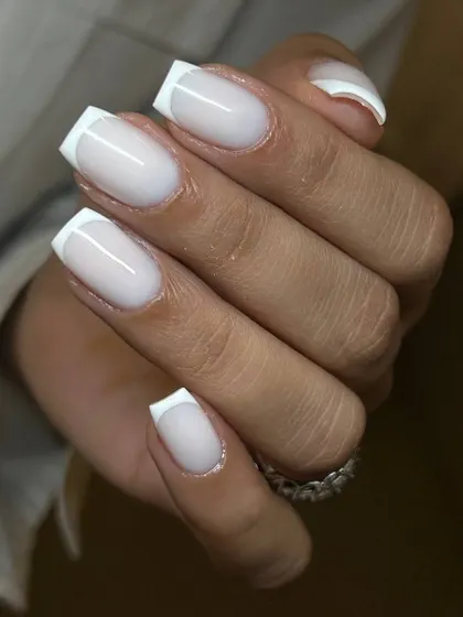 A modern, milky French manicure on square-shaped extensions. The semi-opaque white base softens the look for a chic and updated feel.
