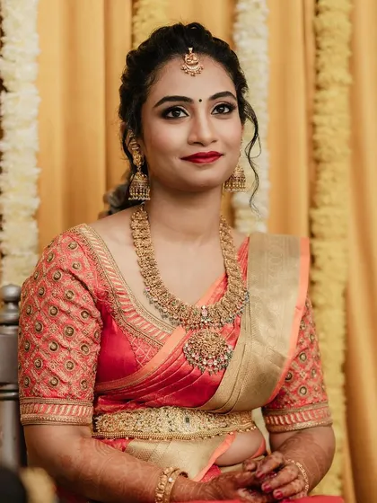 For Dr. Pooja's bangle ceremony, we went for a classic and elegant look. The makeup features a defined eye and a bold red lip, perfectly matching her beautiful silk saree and traditional gold jewellery.