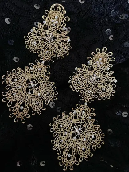 A pair of limited edition danglers crafted to be a "light delight". The intricate, lace like gold work is sprinkled with diamonds, making them a perfect addition for your festive wardrobe.