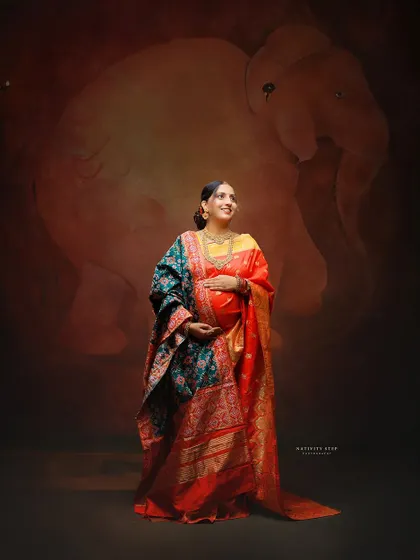 Another variation with a beautiful Patola-style dupatta, adding more texture and richness to the traditional maternity look.