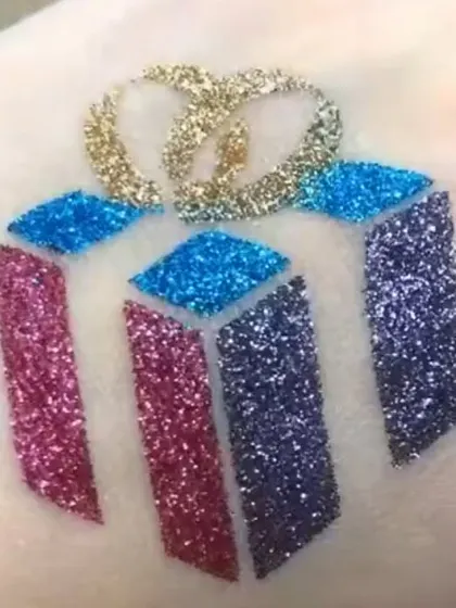 A multi-colored glitter tattoo of a Christmas gift. This is a fun and creative design that captures the excitement of the holiday season.