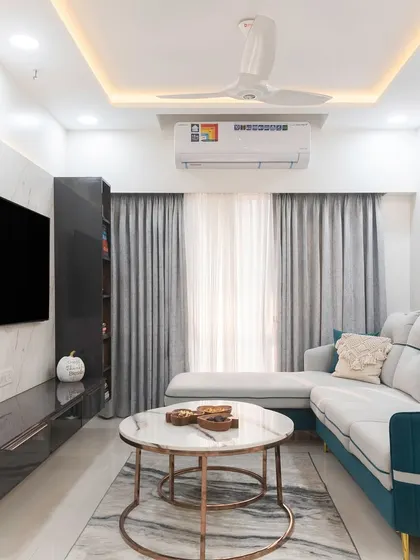 Current obsession: this dreamy living room with a teal and grey L-shaped sofa, a marble-top coffee table, and a sleek, glossy black TV unit.