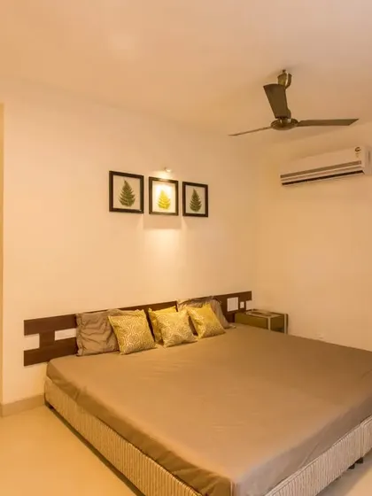 A minimalist bedroom design with clean lines, a simple wooden headboard, and subtle wall art, creating an uncluttered and peaceful sleeping space.