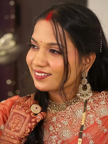 A smiling portrait of bride Mrunali. Her reception makeup is warm and inviting, perfect for celebrating with friends and family.