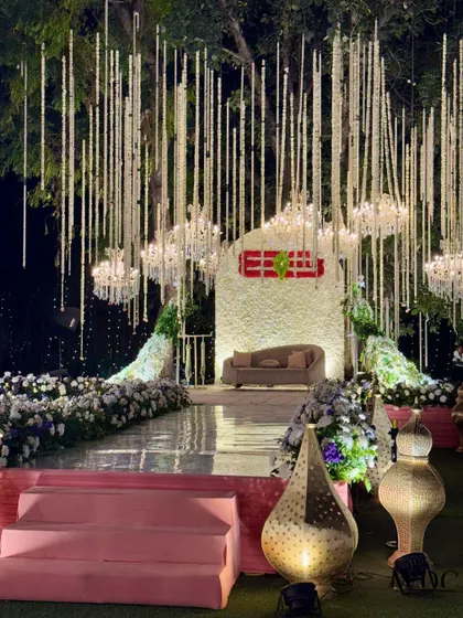 The main stage for the 'Floral Serene Grandeur' theme. A canopy of hanging floral strings and chandeliers creates a dreamy, floating effect over the couple's seating area.