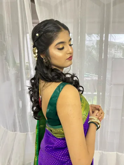 A side profile showing her beautiful gold eye makeup and soft curly hairstyle.