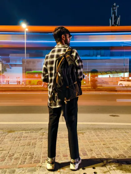 A long-exposure portrait where the subject stands still against the blur of city traffic. This technique creates a powerful contrast between the calm individual and the fast-paced environment.