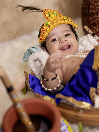 A joyful, candid shot of a baby Krishna with a playful expression. Our goal is to capture the natural personality of your child, even during a themed photoshoot.