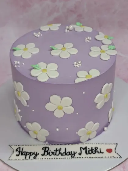 A lovely lilac cake with daisy flowers. This tall chocolate cake has a simple yet elegant design, perfect for Mitthi's birthday.