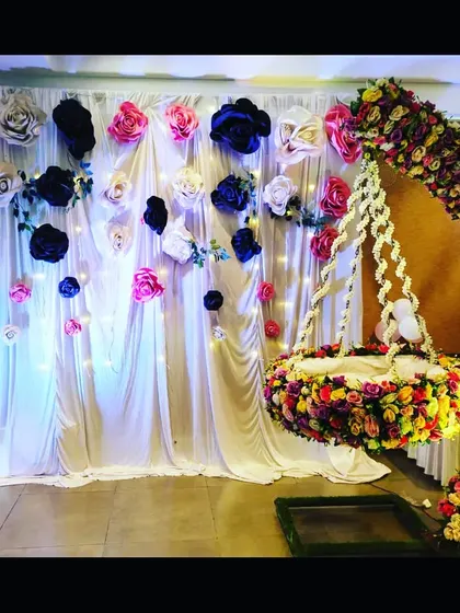 A close-up of the beautiful hanging cradle and paper flower wall, with fairy lights adding a touch of sparkle to the naming ceremony decor.