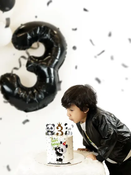 A "then and now" moment. This cool three-year-old is blowing out his birthday candles, and we love looking back at his newborn photos to see how much he has grown.