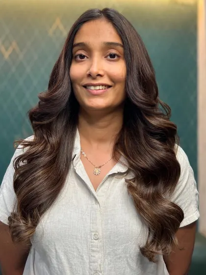 A happy client enjoying her new hair. This look proves that the right shade of brown can instantly brighten your features and boost your confidence.