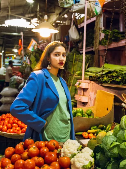 This shot uses the market's own lighting to create a dramatic effect, highlighting the model's pose and the rich colors of the vegetables.