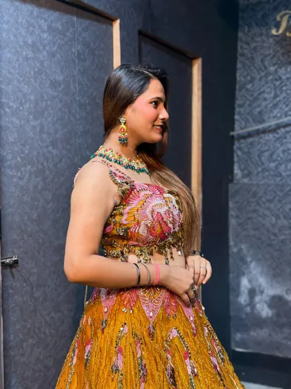 A side profile of a model in the yellow haldi lehenga, showcasing the matching jewellery.
