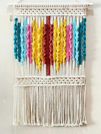 I love playing with color, and this piece shows how different vibrant cords can come together. The textured knots in bright yellow, pink, and teal create a joyful, abstract design.