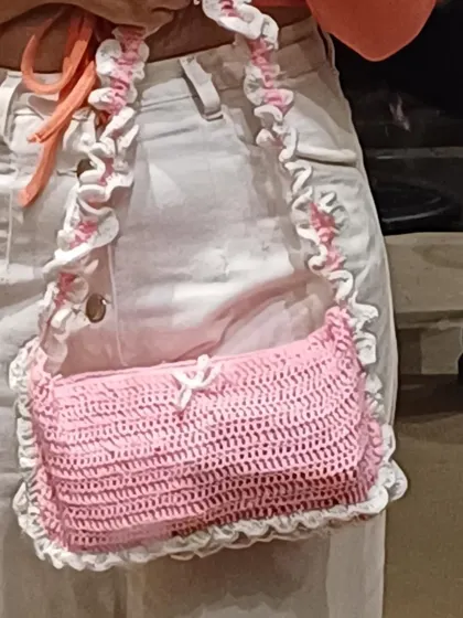 A close-up of my pink and white ruffle shoulder bag. The ruffles on the strap and body give it that super cute coquette look. You can see the little bow detail here too!