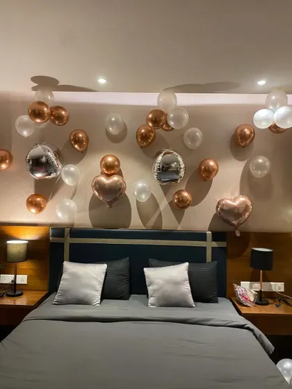 An elegant and minimalist room decoration, using rose gold, white, and disco ball balloons to create a chic birthday atmosphere.