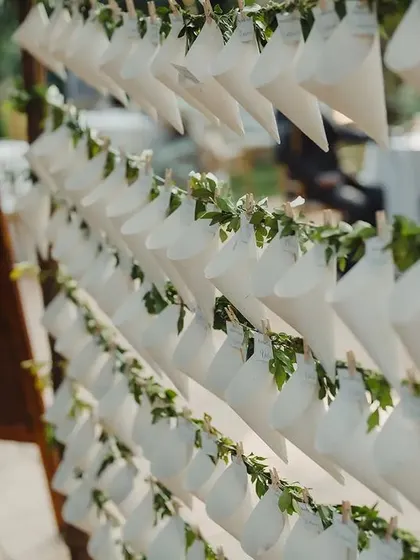 A creative way to guide guests to their seats. We designed these charming paper cones filled with petals, each with a personalized tag indicating the guest's name and their table, which was named after a city the couple had traveled to together.