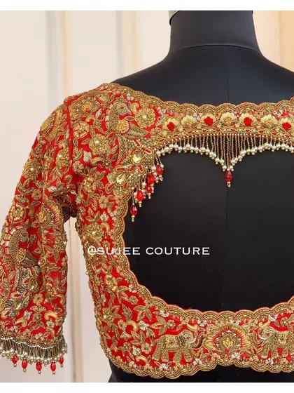I love creating designs that make a statement. This bold red bridal blouse features a dramatic heart-shaped back cutout, heavily embellished with zardozi and finished with delicate pearl tassels for a truly unforgettable look.