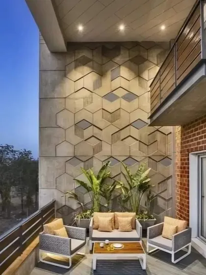 This double-height balcony features a striking 3D geometric wall that adds architectural interest. The modern outdoor furniture and simple planters create a sophisticated and spacious open-air lounge.