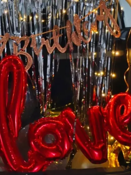 A detailed shot of the 'LOVE' foil balloon in the car boot setup. These small details make a big difference in creating a memorable surprise.