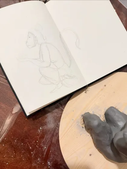 The very beginning of the process. Every sculpture starts with a sketch. Here is my initial drawing in my sketchbook next to the first pieces of clay being shaped.