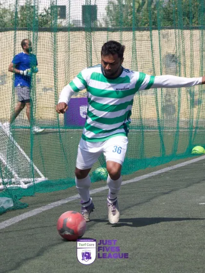 A player from Accenture's team controls the ball, focused on his next move. The green and white striped jersey stands out on the turf.