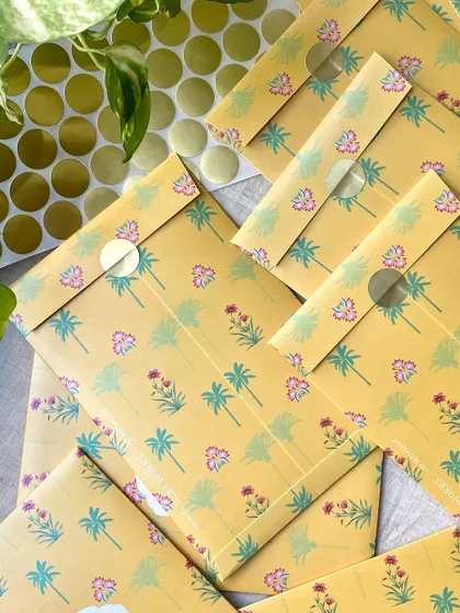 A stack of the sealed yellow floral envelopes. The simple sticker seal is a neat and effective way to close these beautiful, custom-printed envelopes.