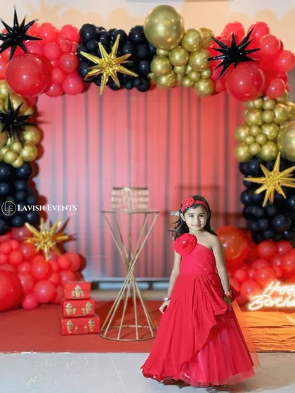 A bold and chic party theme using a dramatic red, black, and gold color palette with star-shaped balloons for a glamorous look.