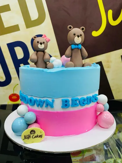 A 2kg gender reveal cake with a pink and blue split design and two teddy bears.