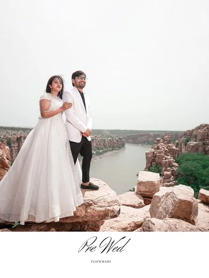 A breathtaking pre-wedding shot of the couple standing on the edge of the Gandikota canyon, showcasing the vast and beautiful landscape.
