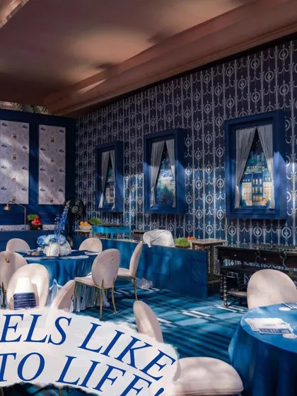The interior of the teddy bear-themed party, showing the custom blue patterned wallpaper and matching tablecloths. Every element is designed to immerse guests in the theme.