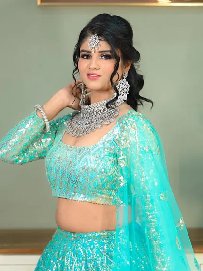 A modern and fresh bridal or sangeet look, featuring a sparkling turquoise lehenga and diamond jewelry.